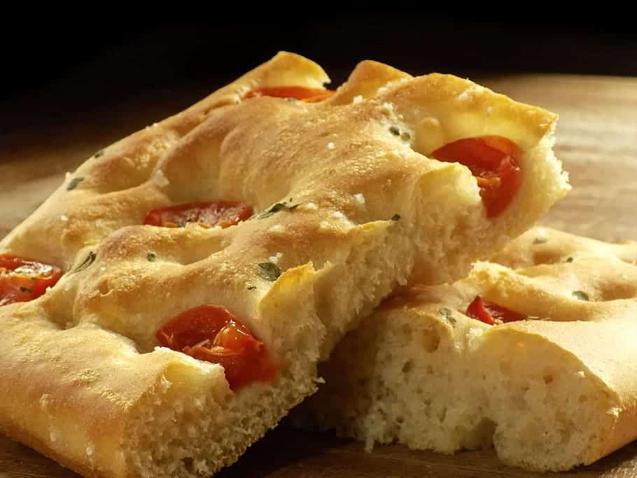 Focaccia barese con pomodorini su un tagliare a tranci